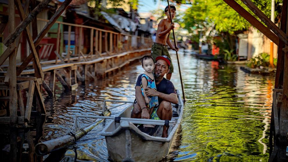 PHOTO: Residents ride a boat in Dela Paz village, which remains flooded since Tropical Storm Trami hit a month ago, on Nov. 20, 2024 in Binan, Laguna province, Philippines.