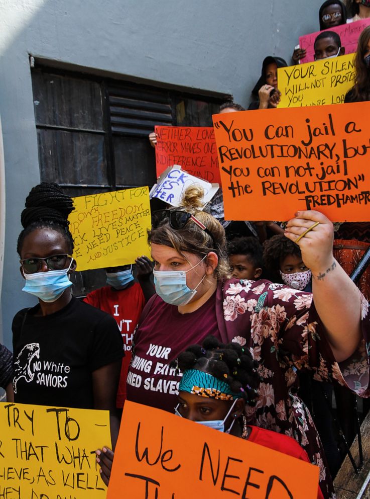 PHOTO: Wendy Lubega (left) and Kelsey Nielsen (right), co-founders of Ugandan advocacy group No White Saviors, hold signs during an anti-racism protest in Kampala, Uganda, on June 9, 2020.