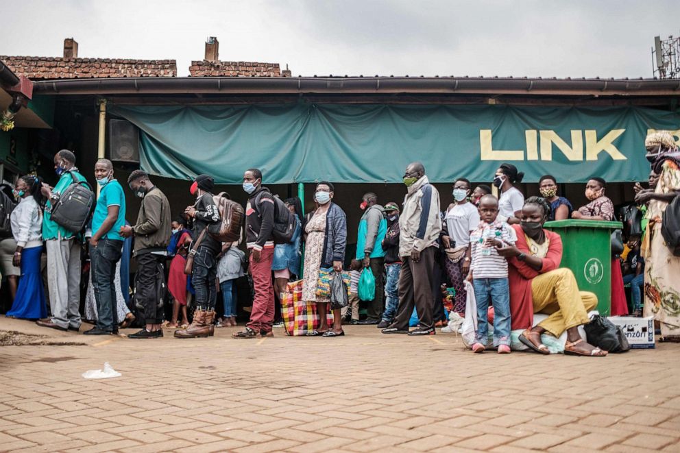 PHOTO: Passengers wait in a queue at a bus terminal to go to back to their villages to vote in the upcoming elections, in Kampala, Uganda, Jan. 12, 2021.