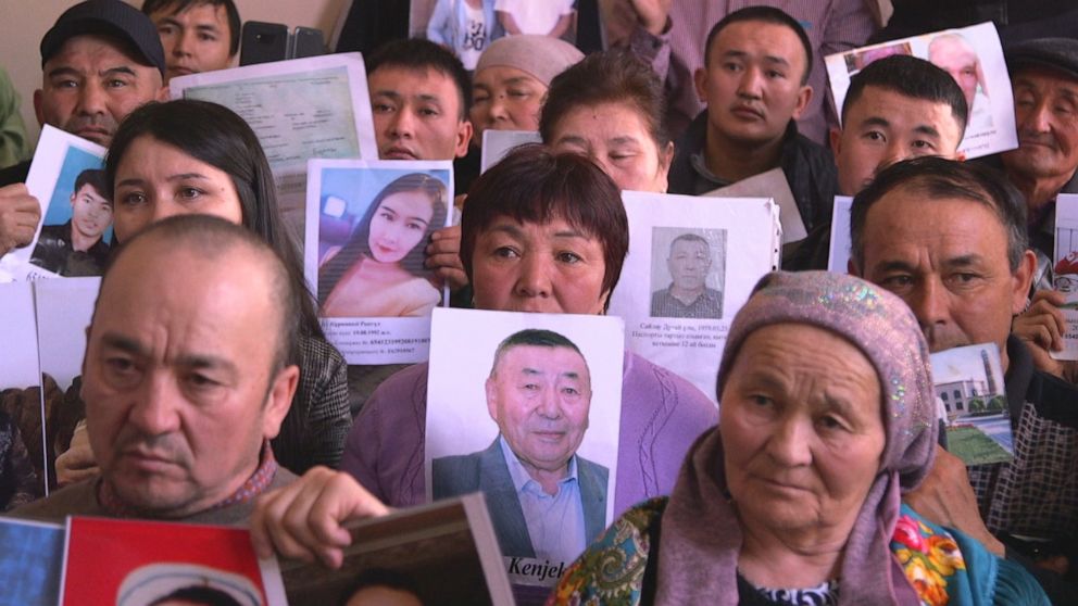 PHOTO: In 2019, Nightline was granted a rare tour of a Chinese vocational center. Here, family members hold up pictures of their missing loved ones.