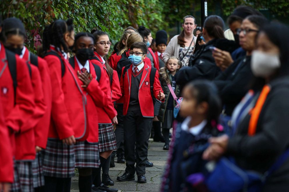 PHOTO: Year 7 students practice social distancing measures and they wait to enter their school at City of London Academy Highgate Hill, Sept. 4, 2020, in London.