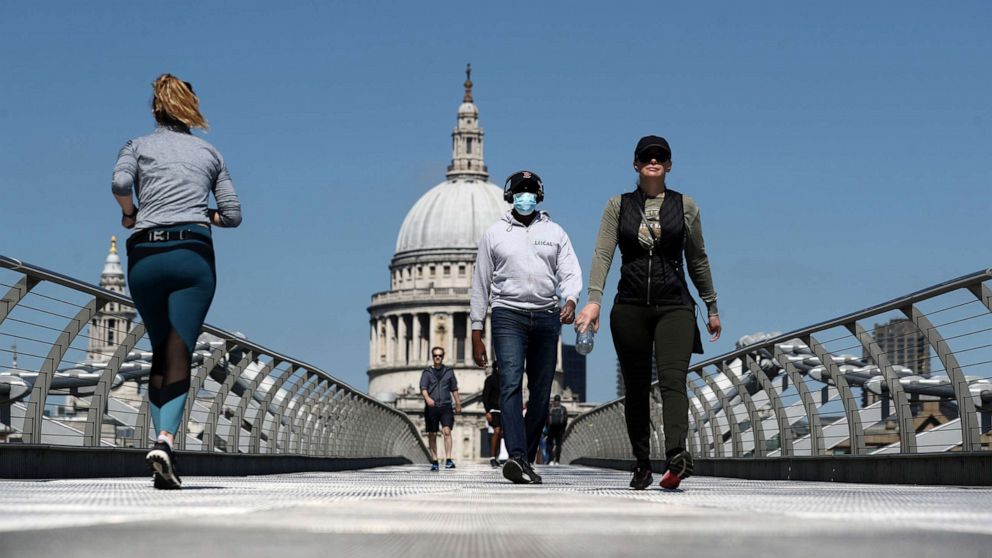 PHOTO: A man wearing a face mask crosses Millennium Bridge, as the spread of the coronavirus disease (COVID-19) continues, in London, Britain, April 25, 2020.