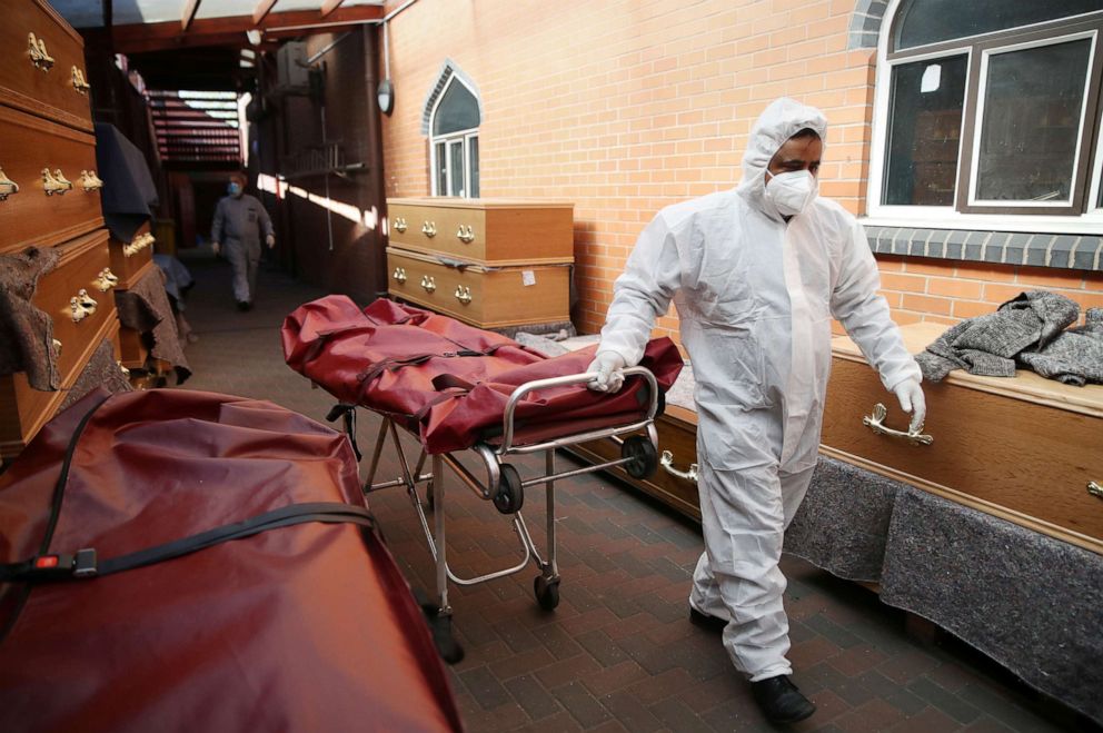 PHOTO: A worker wearing protective equipment moves a stretcher at a temporary morgue set up at a mosque  as the spread of the Coronavirus disease (Covid-19) continues, in Birmingham, Britain, April 21, 2020.
