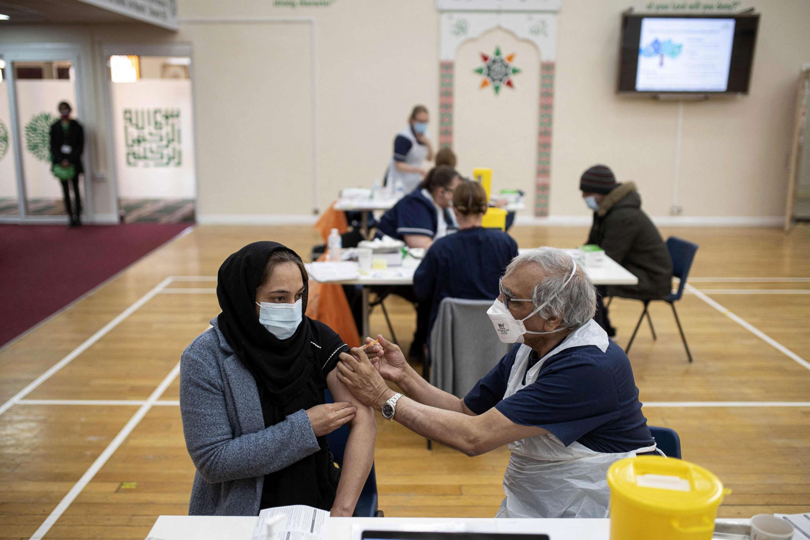 PHOTO: A health worker administers a dose of the AstraZeneca/Oxford Covid-19 vaccine to a patient at a vaccination centre set up at the Karimia Institute Islamic centre and Mosque in Nottingham, England, April 6, 2021.