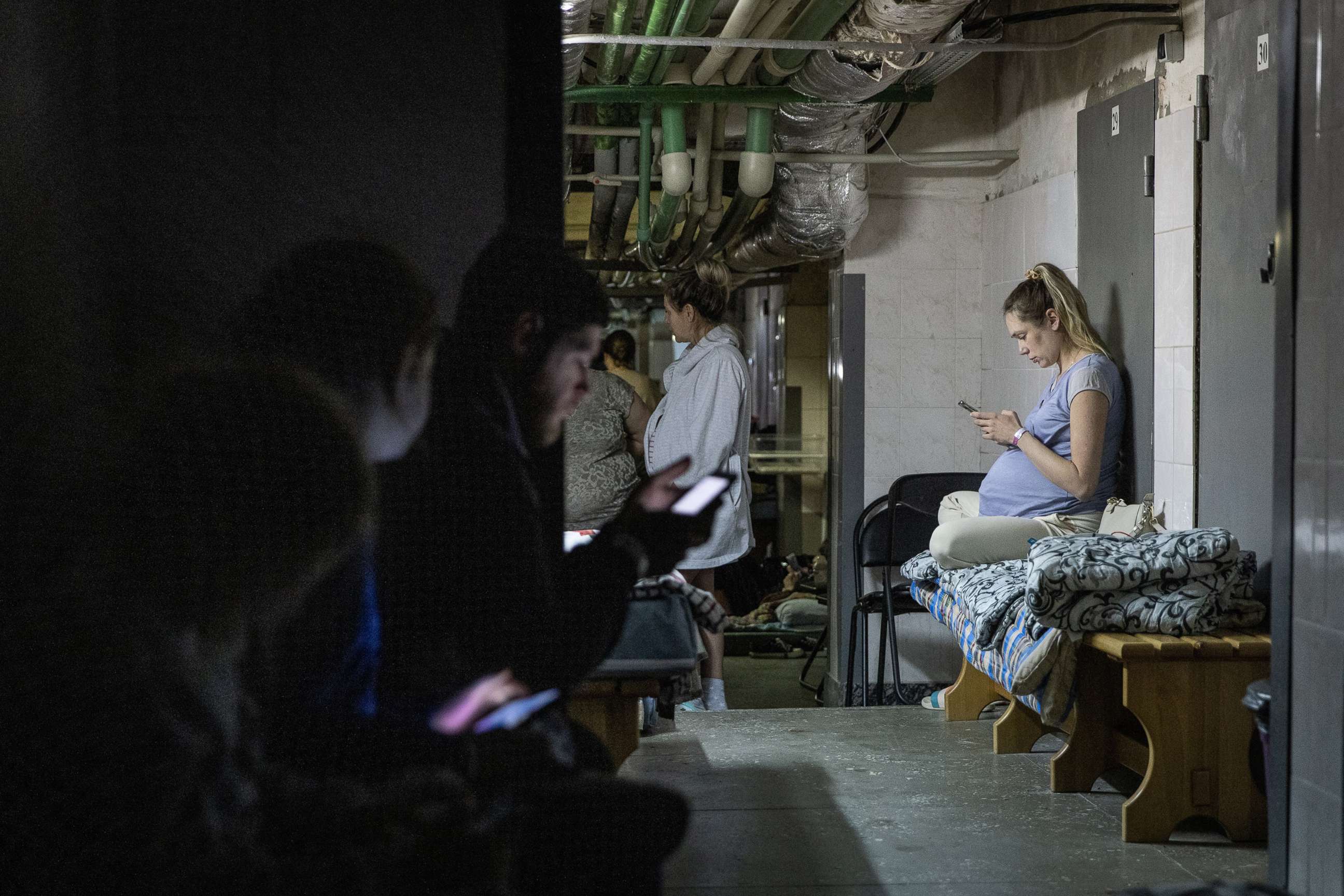 PHOTO: A pregnant woman uses her mobile phone as she rests in the bomb shelter of a maternity hospital, March 2, 2022, in Kyiv, Ukraine.