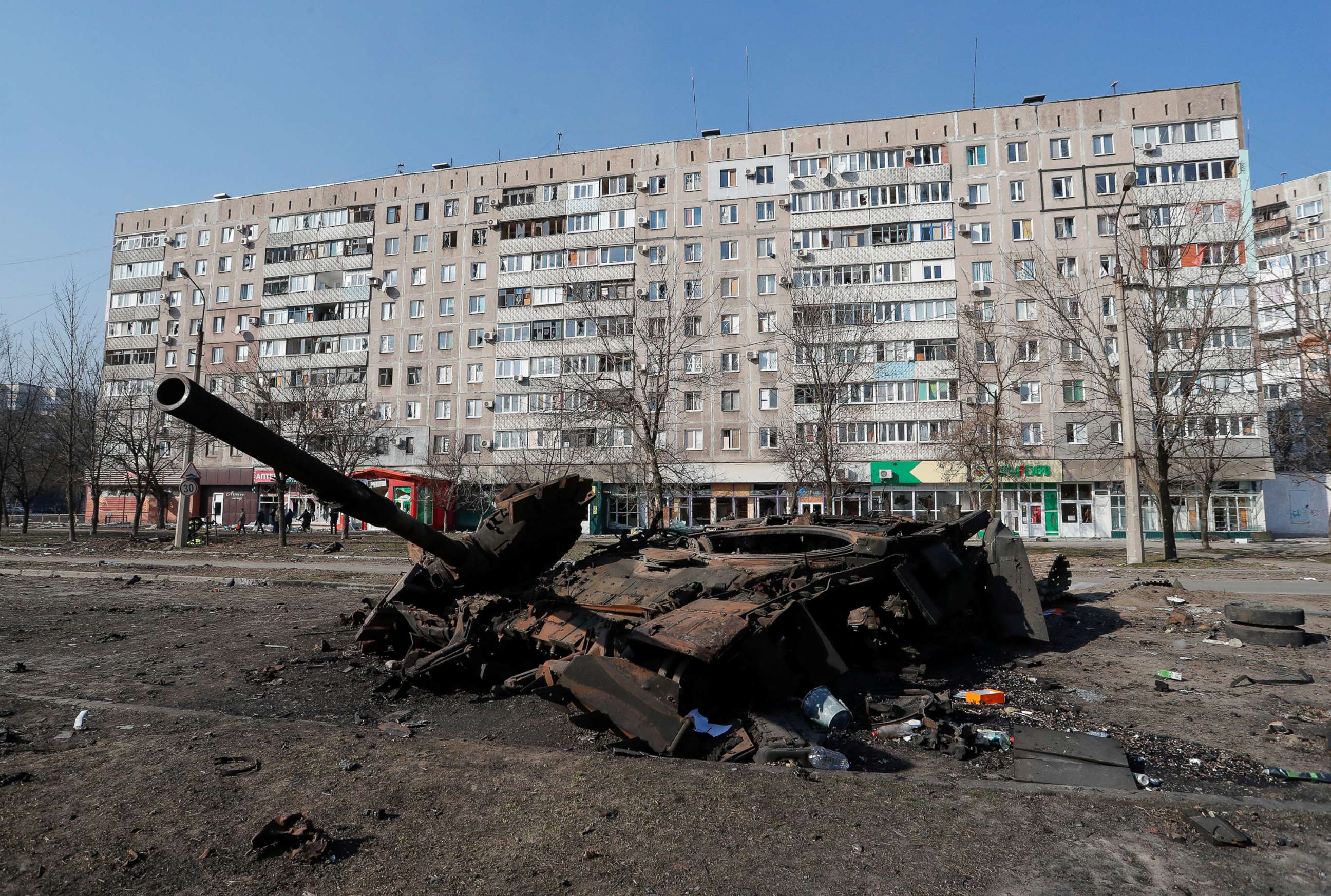 PHOTO: A tank destroyed in fighting during Ukraine-Russia conflict is seen in front of a residential building, in the besieged southern port of Mariupol, Ukraine, March 23, 2022.  