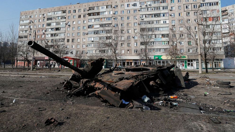 PHOTO: A tank destroyed in fighting during Ukraine-Russia conflict is seen in front of a residential building, in the besieged southern port of Mariupol, Ukraine, March 23, 2022.  