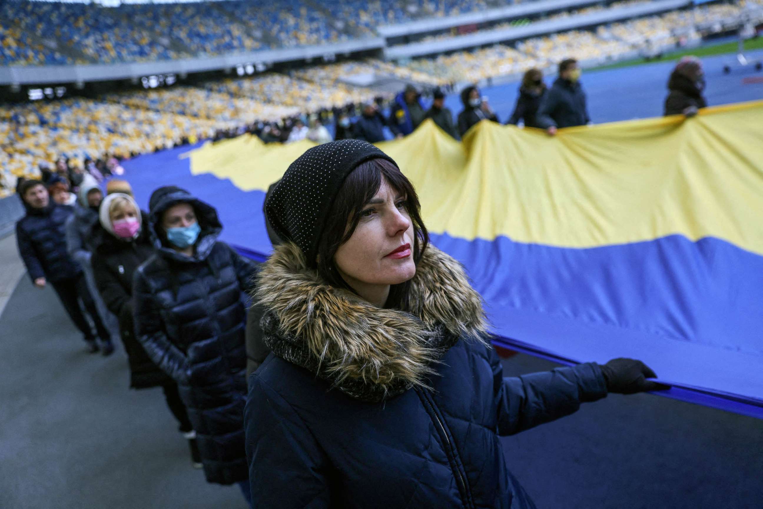PHOTO:  Residents carry the Ukrainian flag as they gather in the Olympic Stadium to mark the national 'Day of Unity' in Kyiv, Ukraine, Feb. 16, 2022.