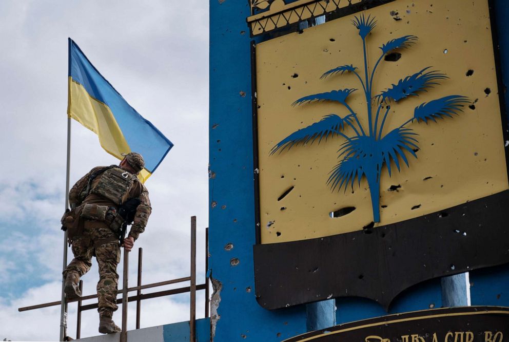PHOTO: A Ukrainian soldier sets up a National flag on the stele on a symbolic border between the Kharkiv and Donetsk areas, Ukraine, Sept. 20, 2022.