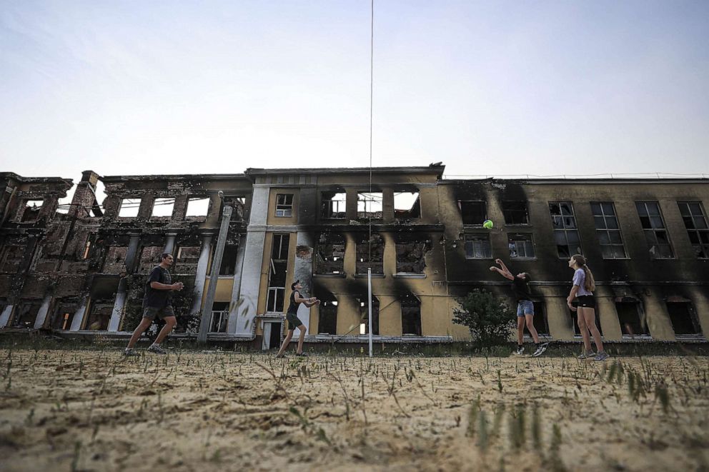 PHOTO: Roman Tetelocko (40), a resident of Kharkiv is seen playing a volleyball with his daughter and her two friends at the sports field located in the playground of a school building, June 10, 2022, in Kharkiv, Ukraine.