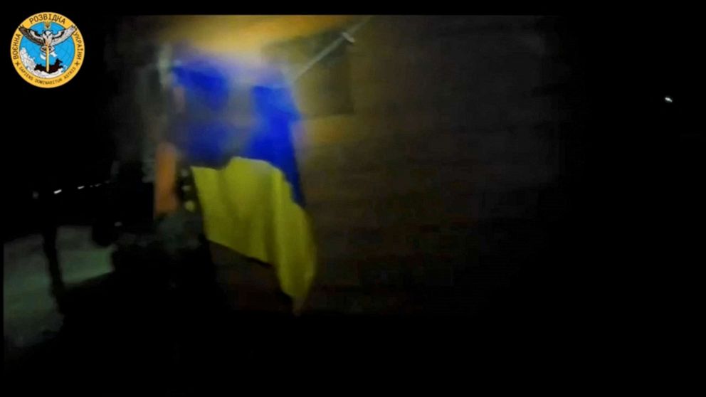 PHOTO: A Ukrainian soldier hangs a Ukrainian flag during a 'special operation' by Ukrainian forces at a location given as near Olenivka and Mayak settlements, Crimea, in this screengrab obtained from a handout video released on August 24, 2023.