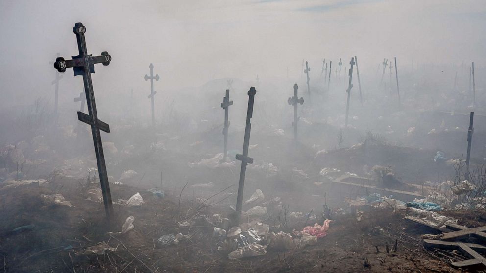 PHOTO: Crosses are pictured under smoke from garbage in the cemetery in Mykolaiv, southern Ukraine, on March 21, 2022.