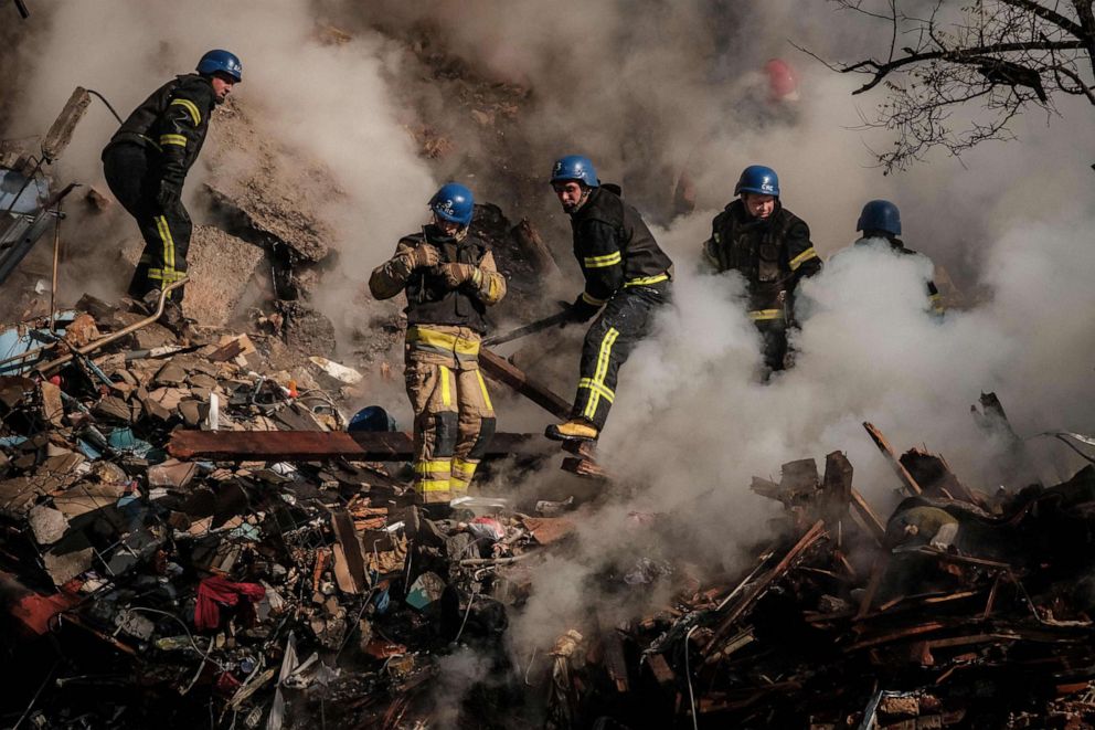 PHOTO: Firefighters works on a destroyed building after a drone attack, Oct. 17, 2022, in Kyiv, Ukraine.