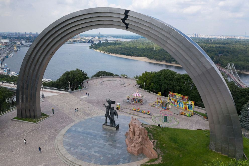 PHOTO: In this June. 23, 2020 file photo people walk in a city park around a Soviet-era monument to Ukraine and Russia's friendship in Kyiv, Ukraine.