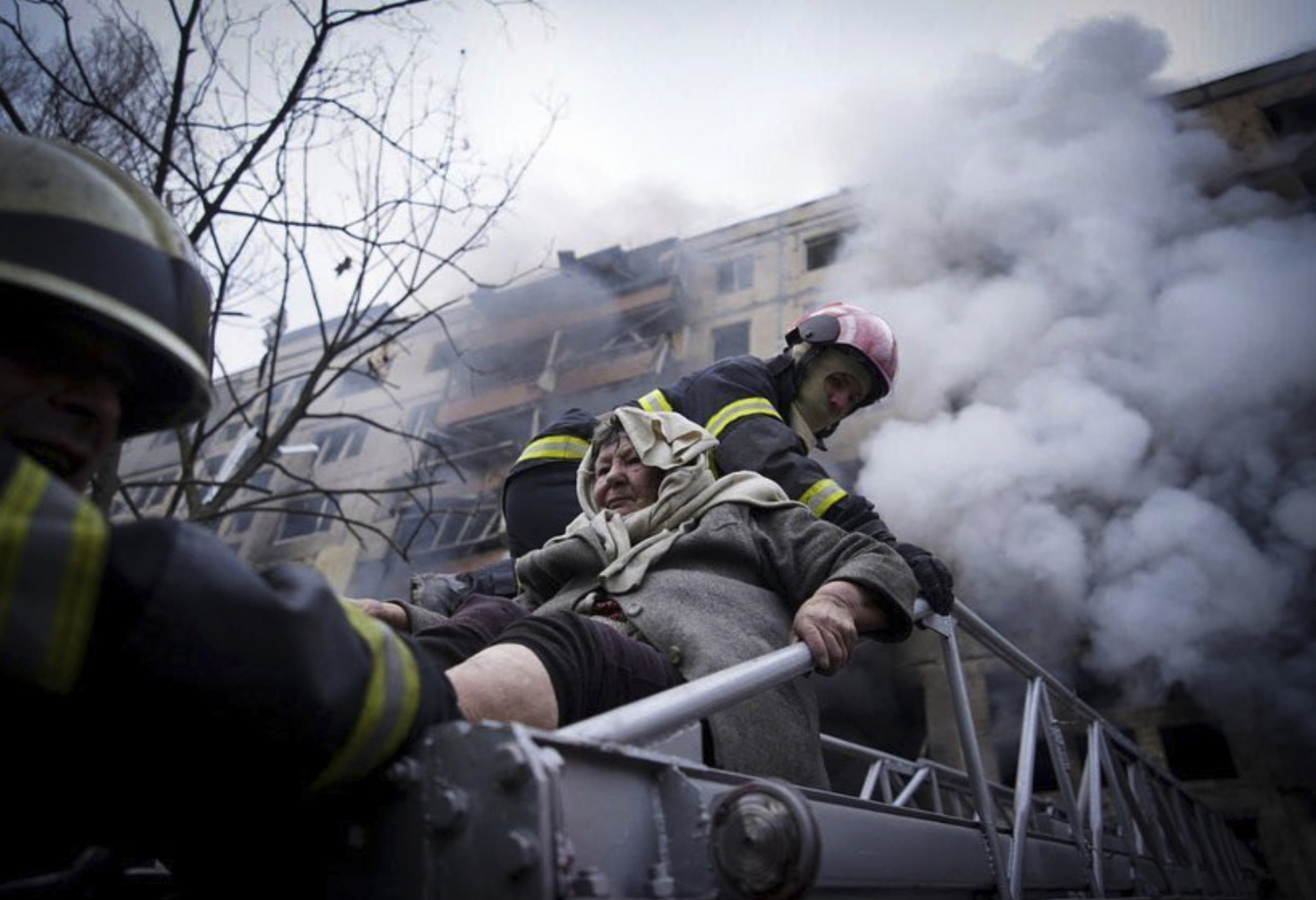 PHOTO: Firefighters evacuate an elderly woman from an apartment building hit by shelling in Kyiv, Ukraine, March 14, 2022.