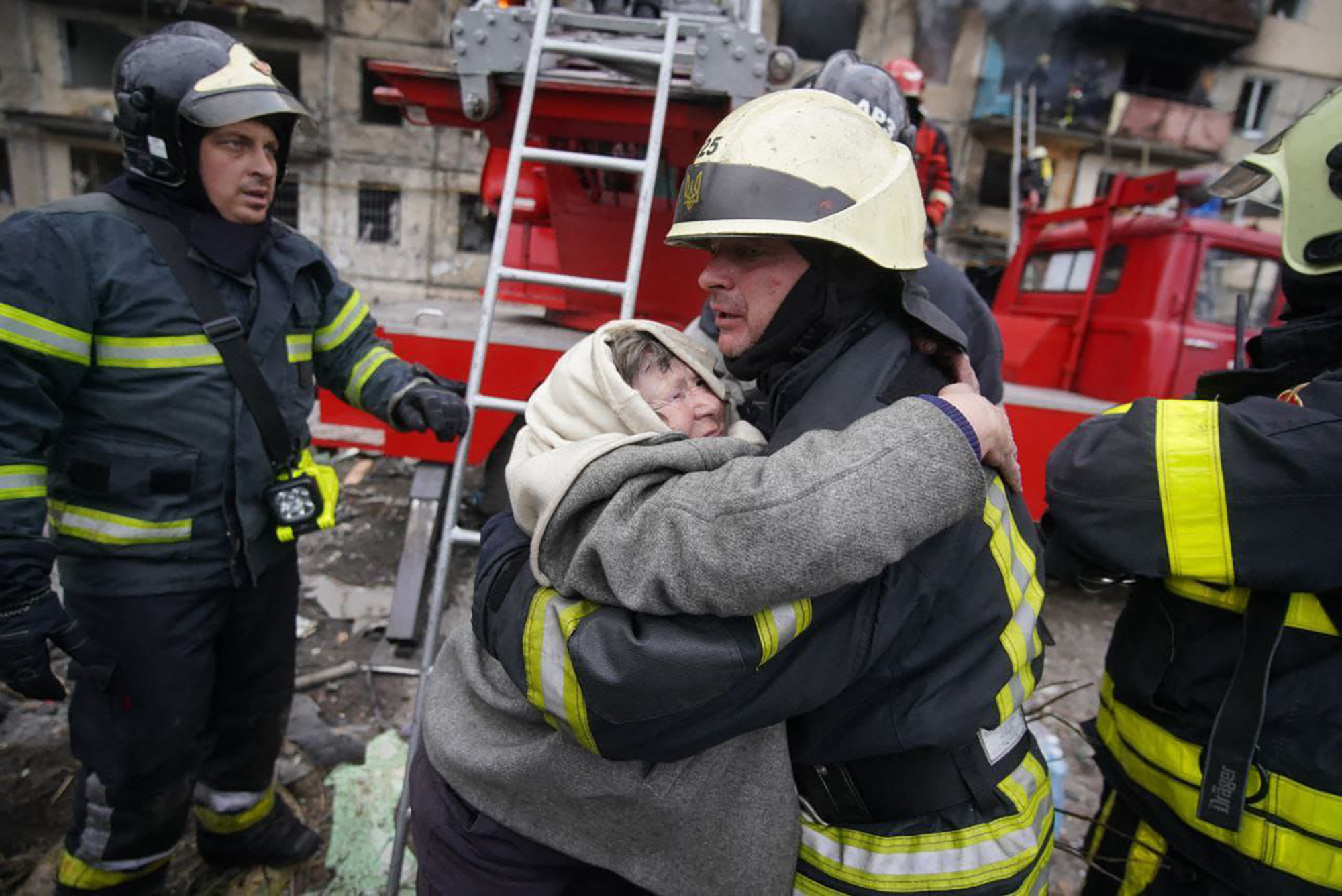 PHOTO: An elderly woman hugs a fireman after being evacuated from an apartment building hit by shelling in the Obolon district of Kyiv in Ukraine, March 14, 2022.