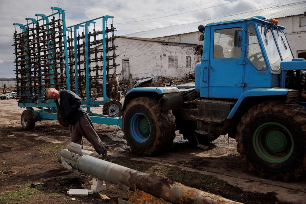 PHOTO: A farm worker looks at a rocket that had landed in a field, at a tractor yard in the village of Yakovlivka, after it was hit by an aerial bombardment outside Kharkiv, as Russia's attack on Ukraine continues, April 3, 2022. 