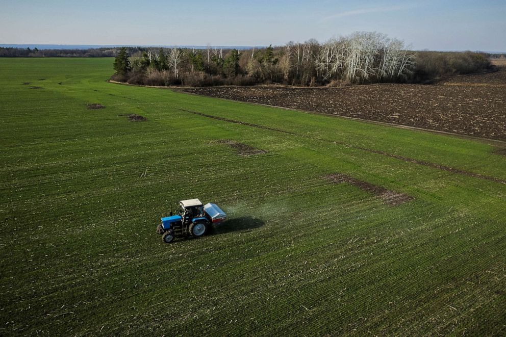PHOTO: An aerial view shows a tractor spreading fertilizer on a wheat field near the village of Yakovlivka after it was hit by an aerial bombardment, outside Kharkiv, April 5, 2022.