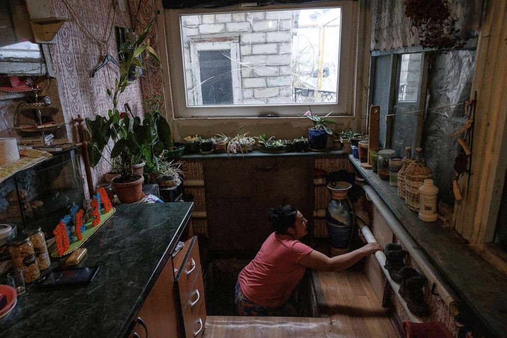 PHOTO: Nina Bonderenko climbs out of the storage cellar where the family hid for the night during an aerial bombardment in the village of Yakovlivka outside Kharkiv, as Russia's attack on Ukraine continues, April 3, 2022. 