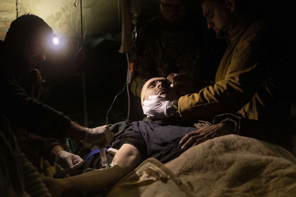 PHOTO: Military medics work on a Ukrainian soldier suffering from head and leg injuries caused by a mine, in a frontline field hospital on Dec. 04, 2022 outside Bakhmut, Ukraine.