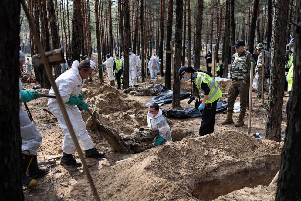 PHOTO: Experts work at a forest grave site during an exhumation in the town of Izium, recently liberated by Ukrainian Armed Forces, in Kharkiv region, Ukraine, Sept. 18, 2022.