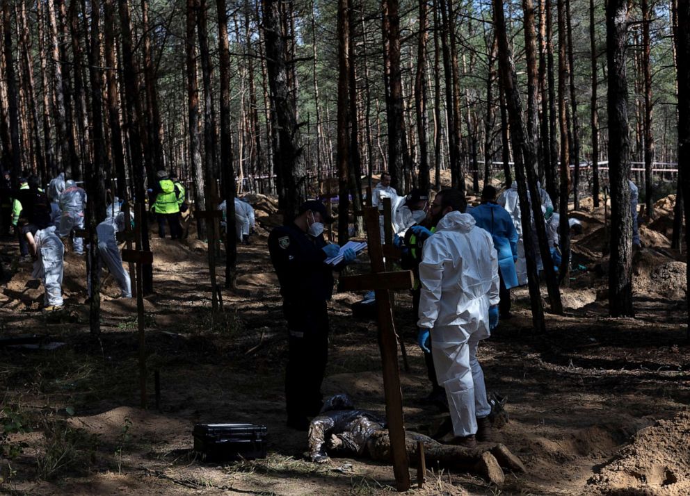 PHOTO: Experts work at a forest grave site during an exhumation in the town of Izium, recently liberated by Ukrainian Armed Forces, in Kharkiv region, Ukraine, Sept. 18, 2022. 