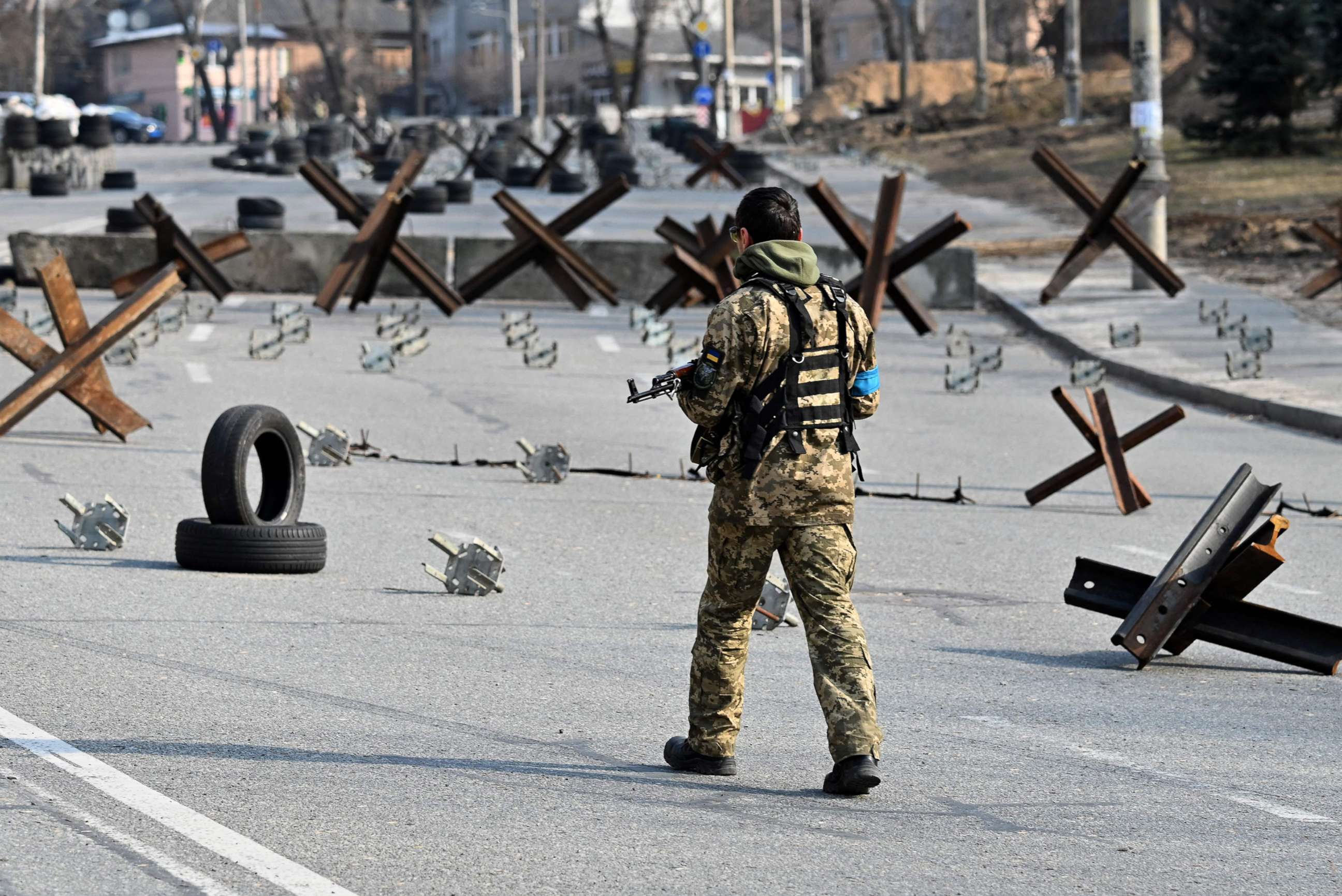 PHOTO: A Ukrainian soldier passes by anti-tank protection elements as he stands guard at a checkpoint in the outskirt of Kyiv, on March 28, 2022.