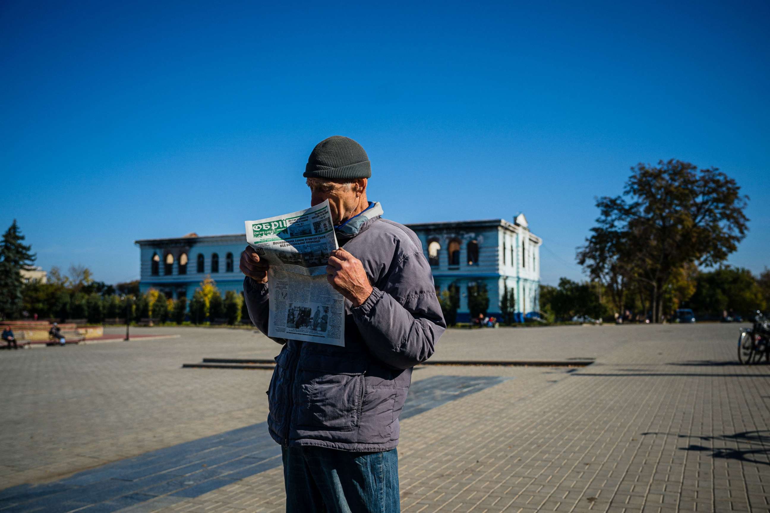 PHOTO: This photo taken on Oct. 18, 2022, shows a local resident reading a newspaper while he waits to receive a food package on the central square in the town of Izyum, amid Russia's invasion of Ukraine.