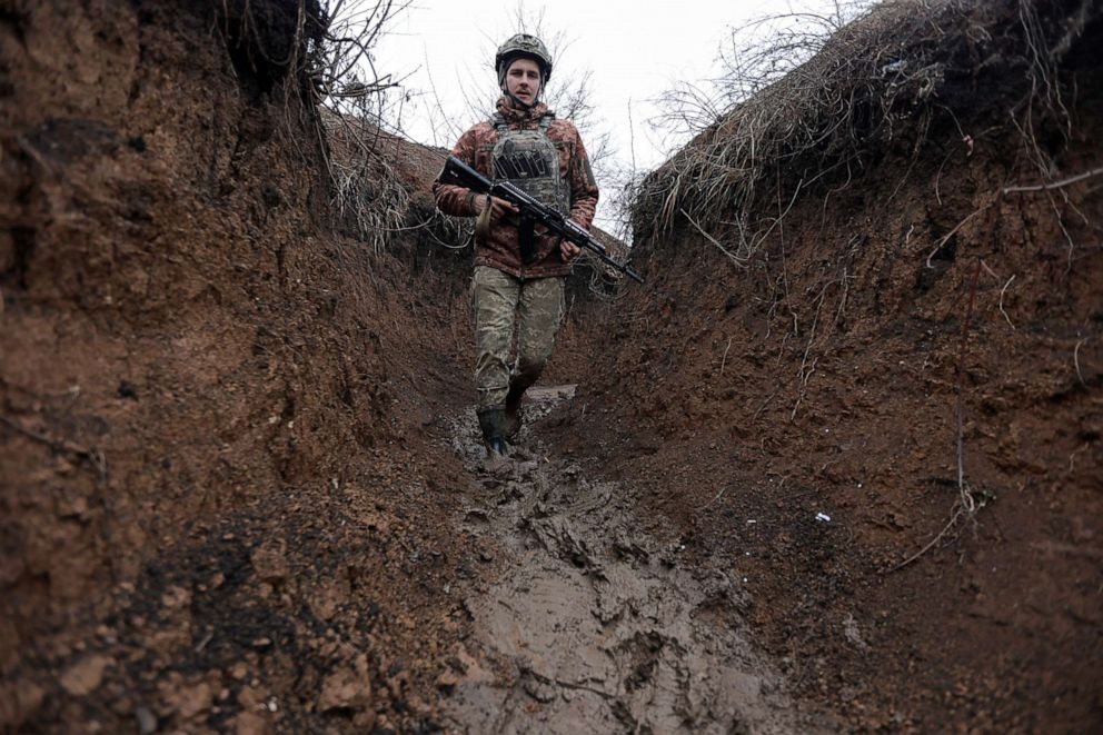 PHOTO: A service member of the Ukrainian armed forces walks along a trench at combat positions near the line of separation from Russian-backed rebels outside Zolote in the Luhansk region, Ukraine, Dec. 11, 2021.