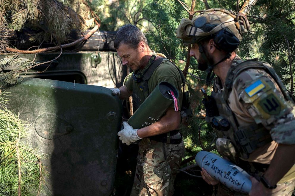 PHOTO: Ukrainian soldiers load a howitzer with a shell with 'for Latyk Boris' witten on it on the frontline in the outskirts of Lyman, Ukraine, on Aug. 15, 2023.