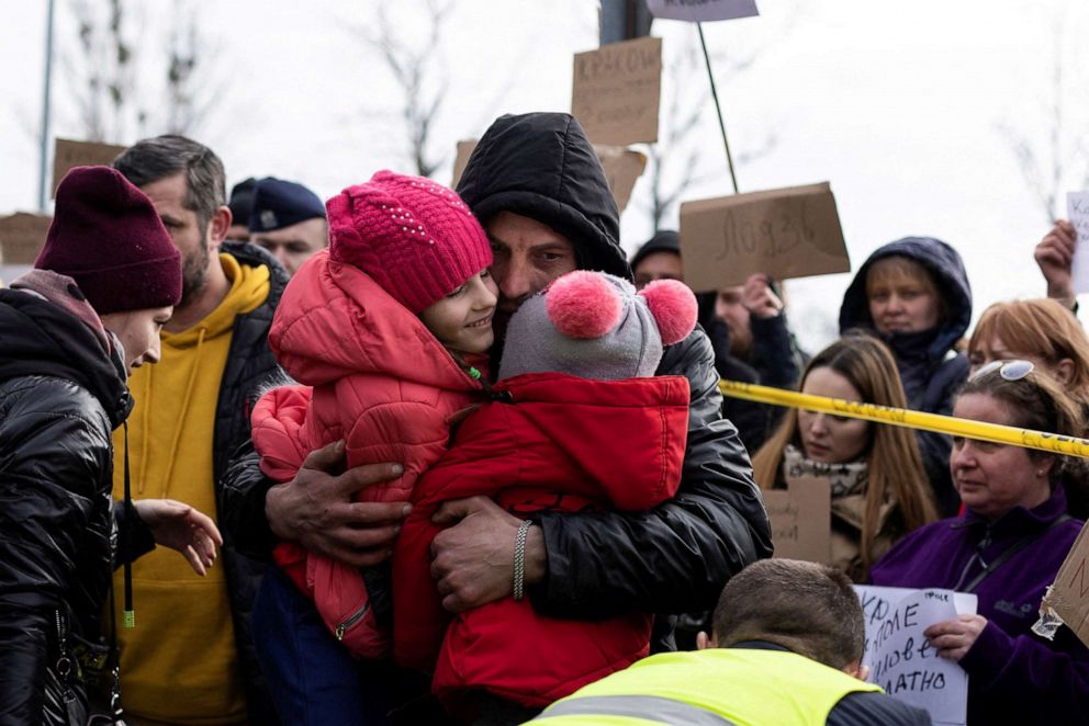 PHOTO: A man hugs his daughters after they arrived in Poland from Ukraine, in Przemysl, Poland, Feb. 27, 2022.