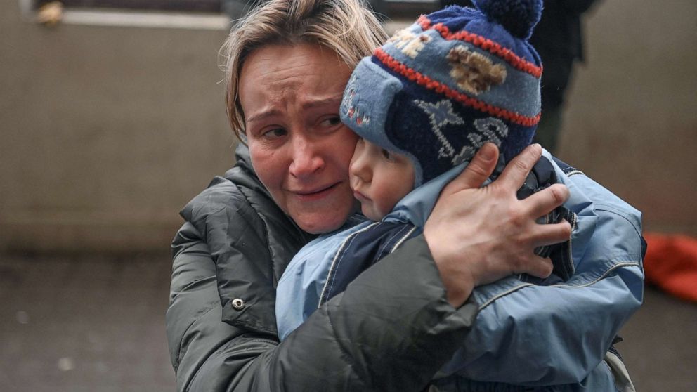 PHOTO: A woman holds her child as she tries to board into a free train to Poland at a train station in Lviv, western Ukraine, March 3, 2022.