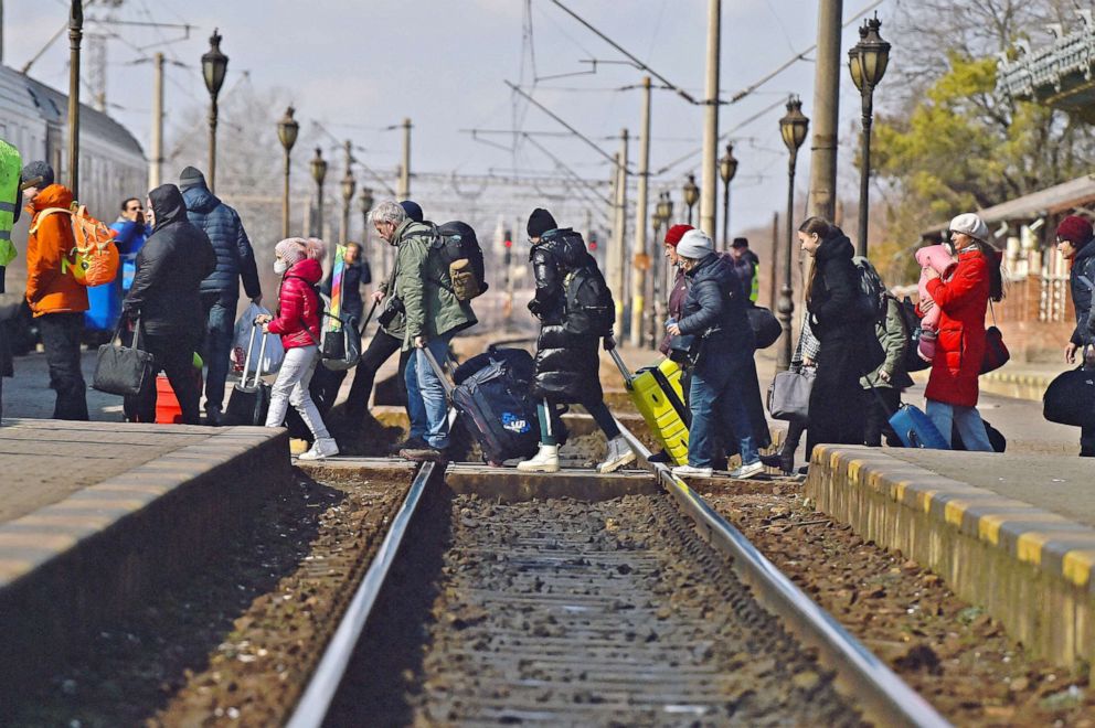 PHOTO: Refugees walk across train tracks to board a train to Bucharest at Suceava train station, after fleeing Ukraine to the Siret border crossing in Romania, following Russia's invasion of Ukraine, in Suceava, Romania, March 17, 2022. 