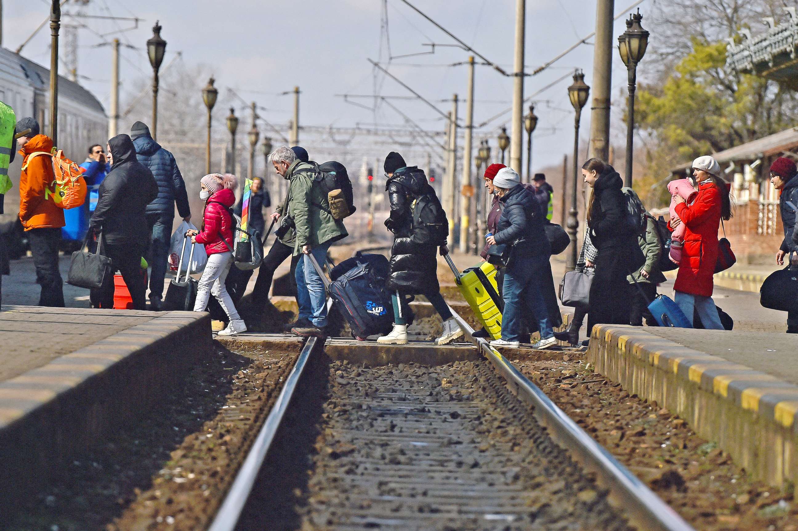 PHOTO: Refugees walk across train tracks to board a train to Bucharest at Suceava train station, after fleeing Ukraine to the Siret border crossing in Romania, following Russia's invasion of Ukraine, in Suceava, Romania, March 17, 2022. 