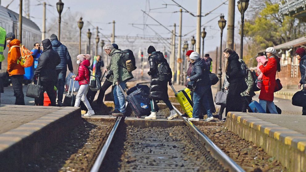 PHOTO: Refugees walk across train tracks to board a train to Bucharest at Suceava train station, after fleeing Ukraine to the Siret border crossing in Romania, following Russia's invasion of Ukraine, in Suceava, Romania, March 17, 2022. 
