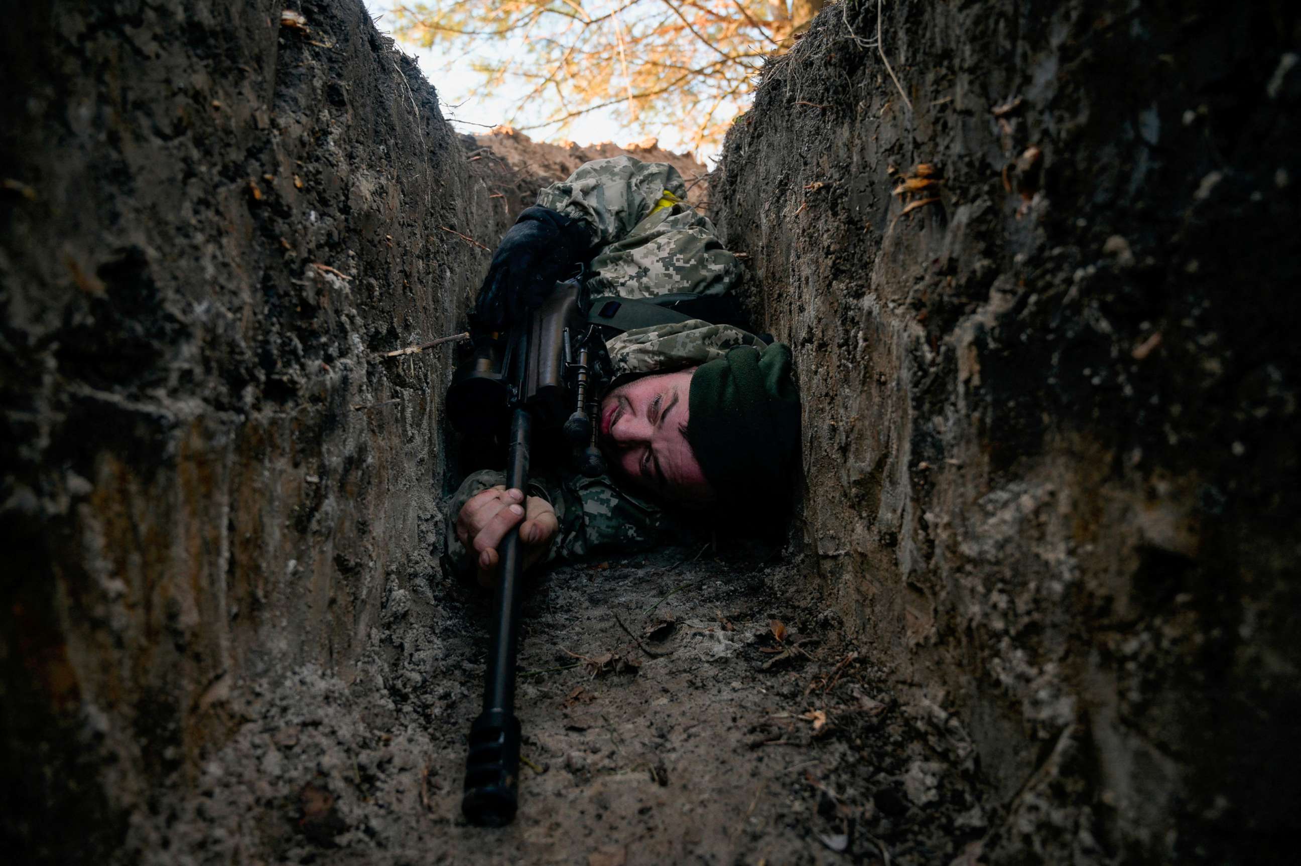 PHOTO: A Ukrainian soldier hides from a helicopter airstrike amid Russia's invasion of Ukraine, near Demydiv, Ukraine on March 10, 2022.