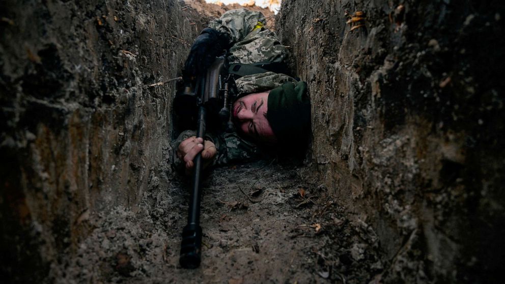 PHOTO: A Ukrainian soldier hides from a helicopter airstrike amid Russia's invasion of Ukraine, near Demydiv, Ukraine on March 10, 2022.
