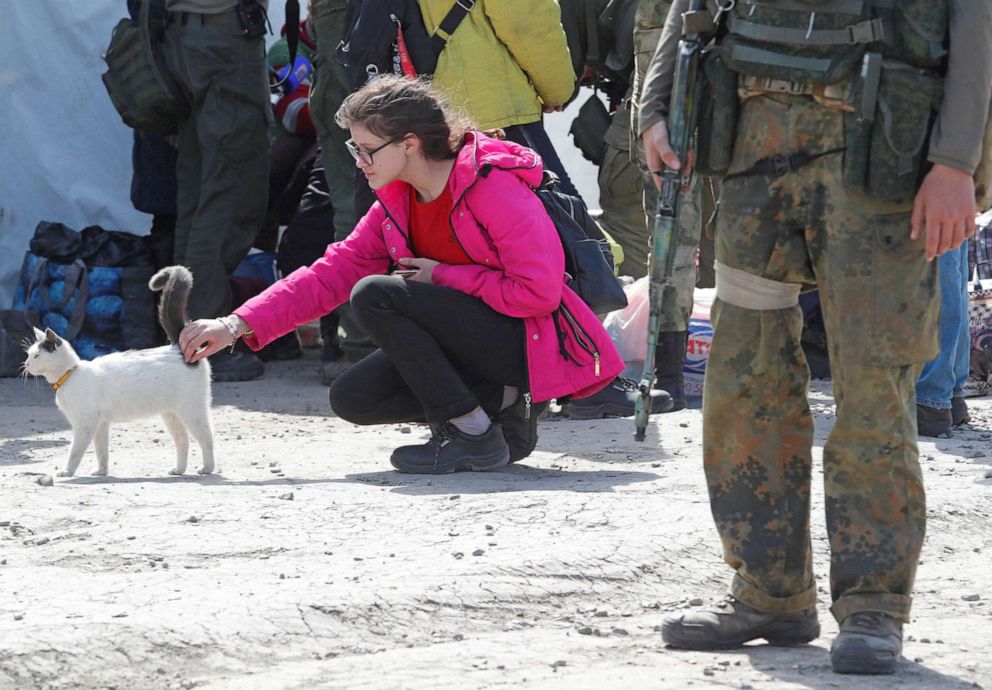 PHOTO: A young woman strokes a cat as evacuees, including civilians who left the area near Azovstal steel plant in Mariupol, arrive at a temporary accommodation centre in the village of Bezimenne in the Donetsk Region, Ukraine May 1, 2022. 
