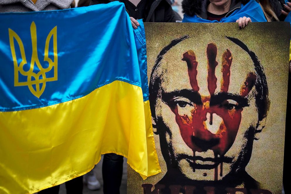 PHOTO: A protestor holds a banner depicting Russian President Vladimir Putin during a demonstration in front of the Russian Embassy in Madrid, Feb. 24, 2022.