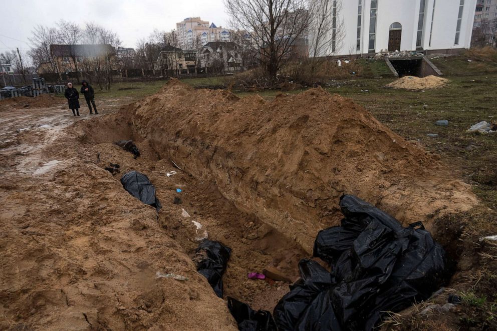 PHOTO: Neighbors gather next to a mass grave in Bucha, in the outskirts of Kyiv, Ukraine, April 3, 2022.