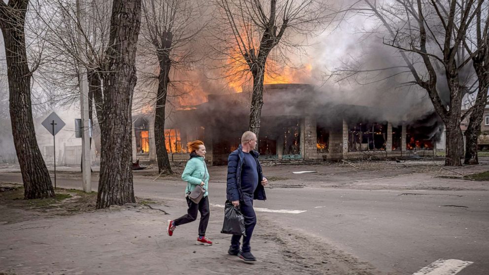 PHOTO: Residents run near a burning house following a shelling Severodonetsk, Donbass region, Ukraine, April 6, 2022.