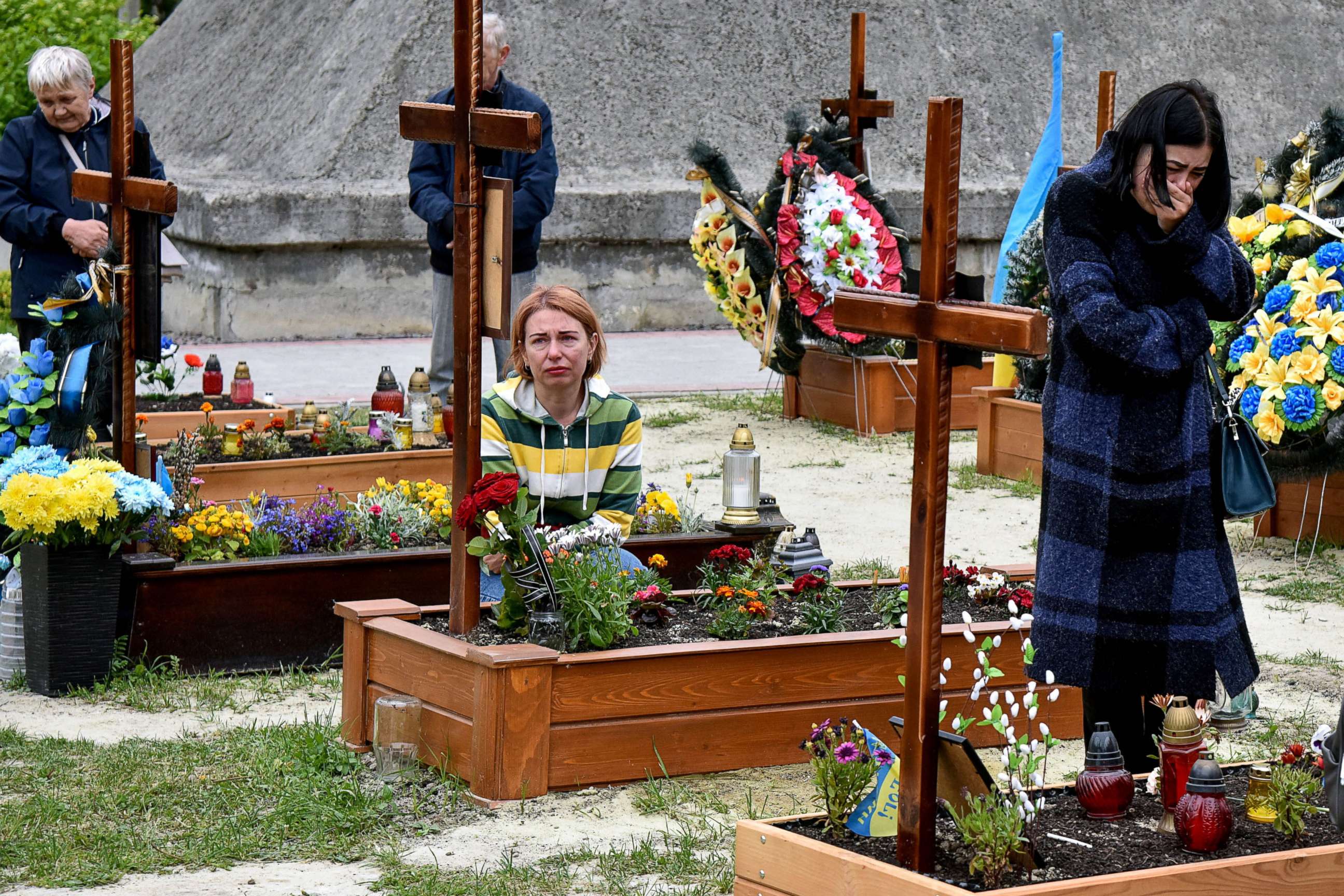 PHOTO: People pay respects next to graves at Lychakiv Cemetery where some people killed in Russia's invasion of Ukraine are buried as the Day of Heroes of Heavenly Hundred is celebrated, in Lviv, Ukraine May 22, 2022