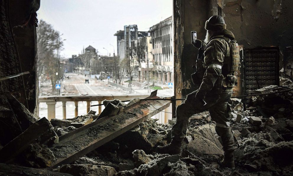 PHOTO: A Russian soldier patrols at the bombed out remains of Mariupol drama theatre in in Mariupol, Ukraine, April 12, 2022. 