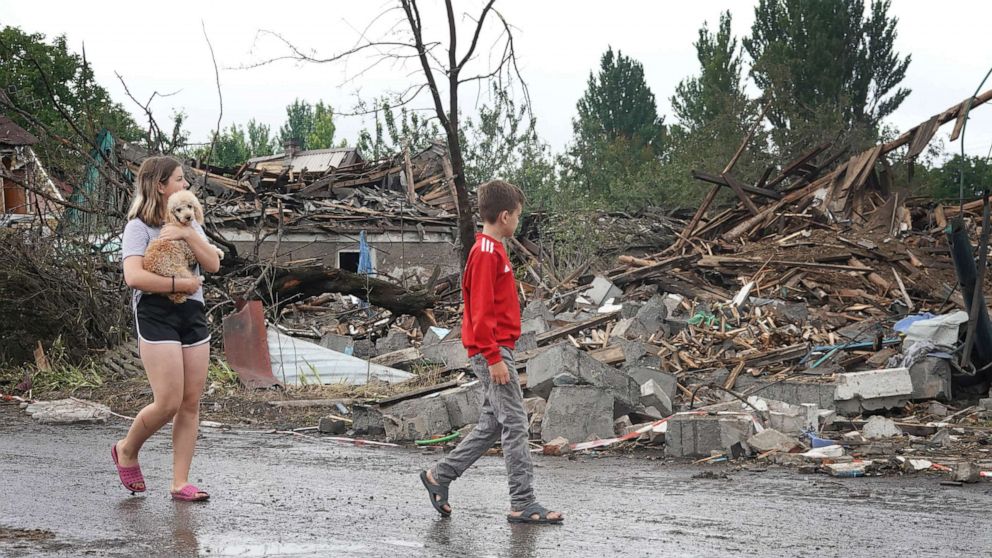 PHOTO: Children walk past homes in their neighborhood that were completely destroyed by a Russian rocket attack in Dobropillia, Ukraine, June 15, 2022.