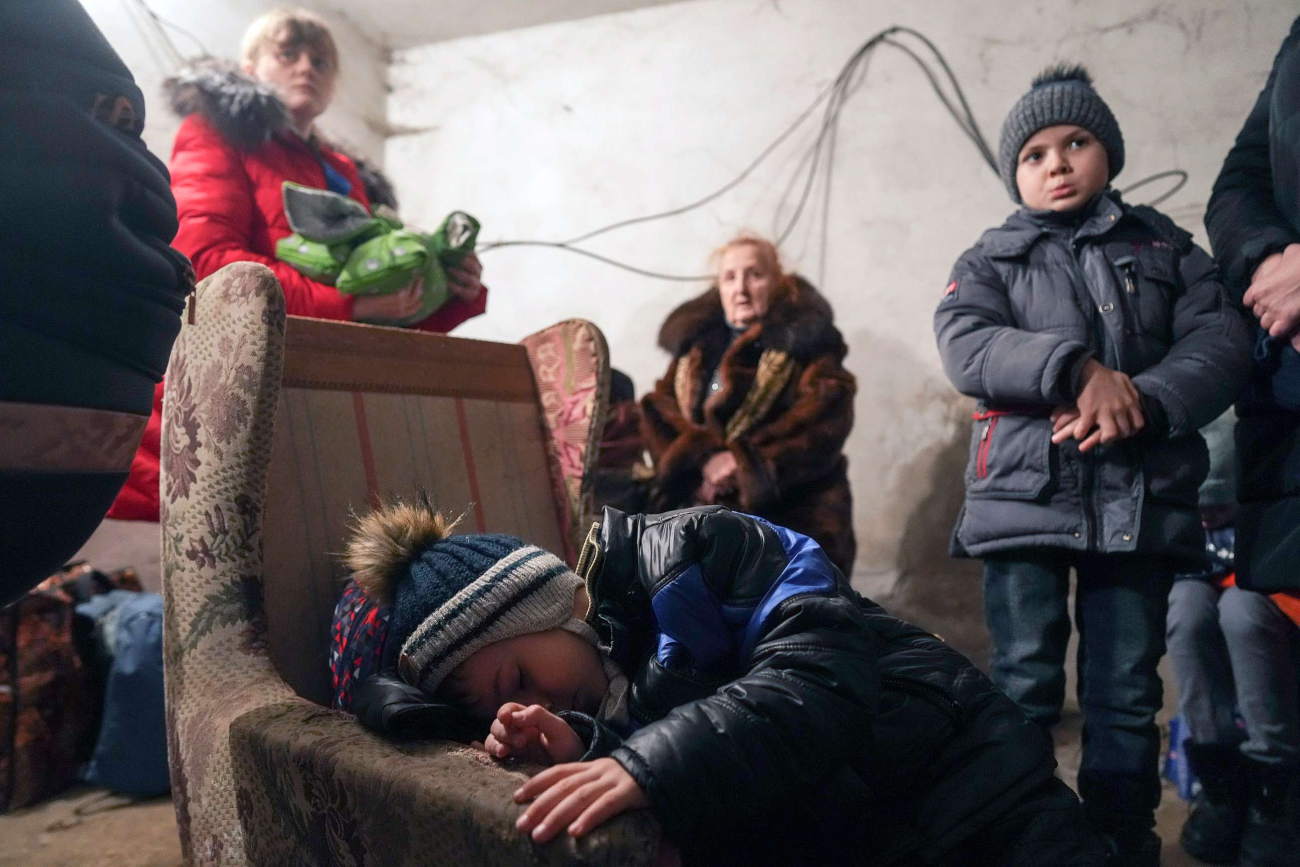 PHOTO: A child sleeps in an armchair as others gather in a shelter during Russian shelling, in Mariupol, Ukraine, Feb. 24, 2022. 