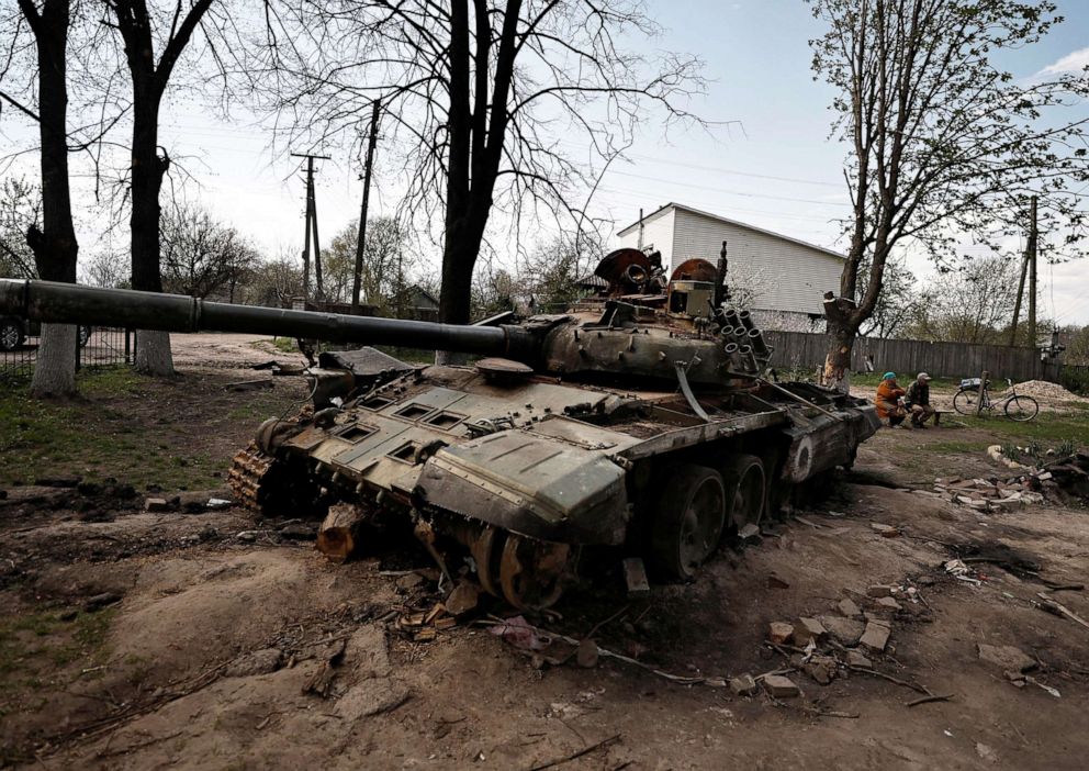 PHOTO: Ulyana Pishchur, 72, sits on bench near a destroyed Russian tank outside the village council building, amid Russian invasion of Ukraine in Sloboda, Chernihiv region, Ukraine, on May 3, 2022.