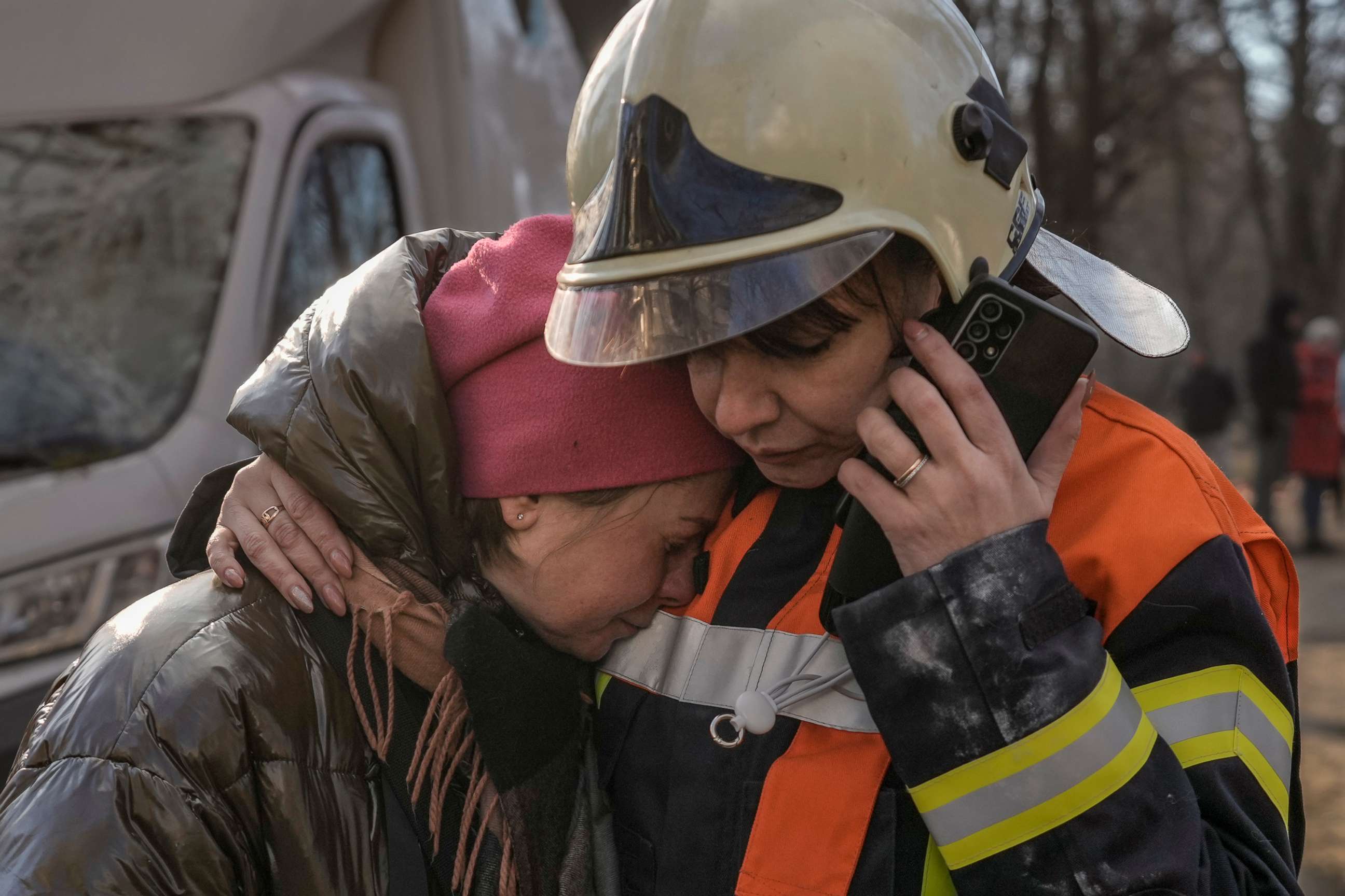 PHOTO: A firefighter comforts a woman outside a destroyed apartment building in a residential area in Kyiv, Ukraine, March 15, 2022.