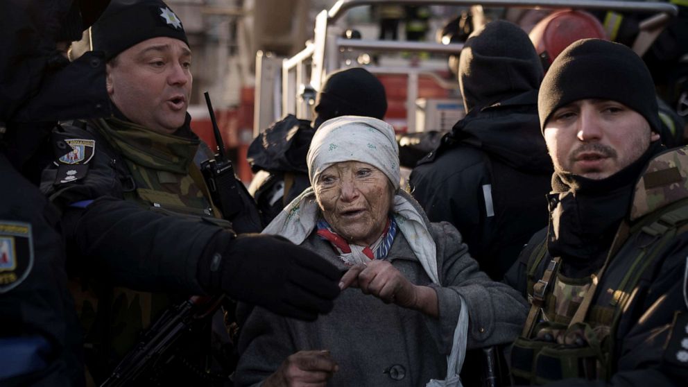 PHOTO: An elderly woman is helped by policemen after she was rescued by firefighters from inside her apartment in Kyiv, Ukraine, March 15, 2022.