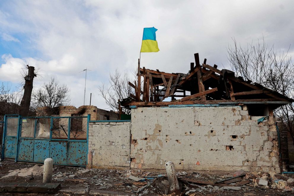 PHOTO: A Ukrainian flag is installed on an apartment building damaged by fighting between Russian and Ukrainian troops in Lukyanivka, a neighborhood of Kyiv, Ukraine, on March 27, 2022.