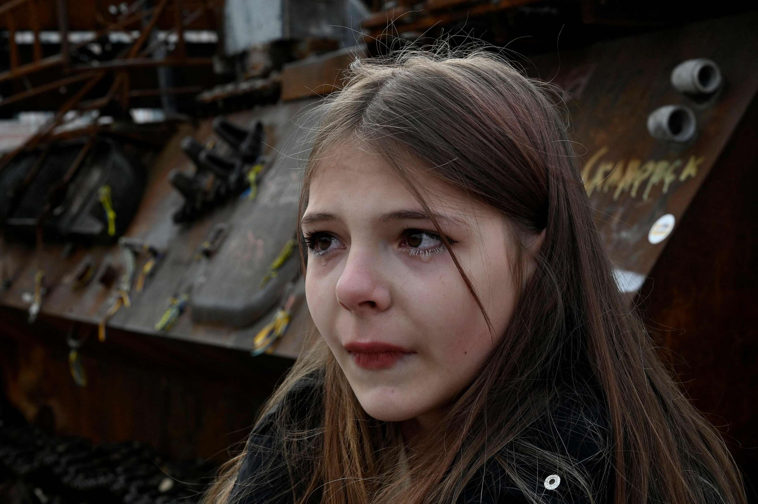 PHOTO: Spivak Nastya, a 13-year-old Ukrainian refugee from the war-torn Donetsk region, reacts as she talks with journalists next to a tank at an open air exhibition of destroyed Russian armored equipment in the center of Kyiv, Ukraine, on May 9, 2023.